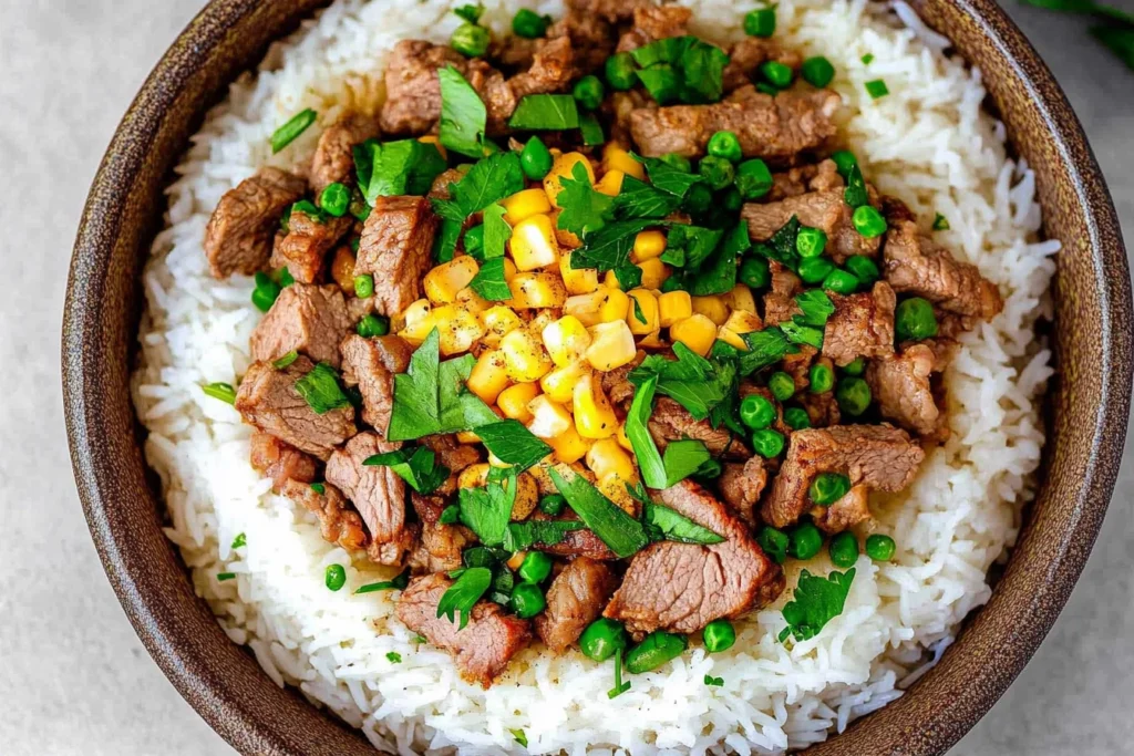 Beef sautéing in a skillet with garlic and soy sauce for Beef Pepper Rice.