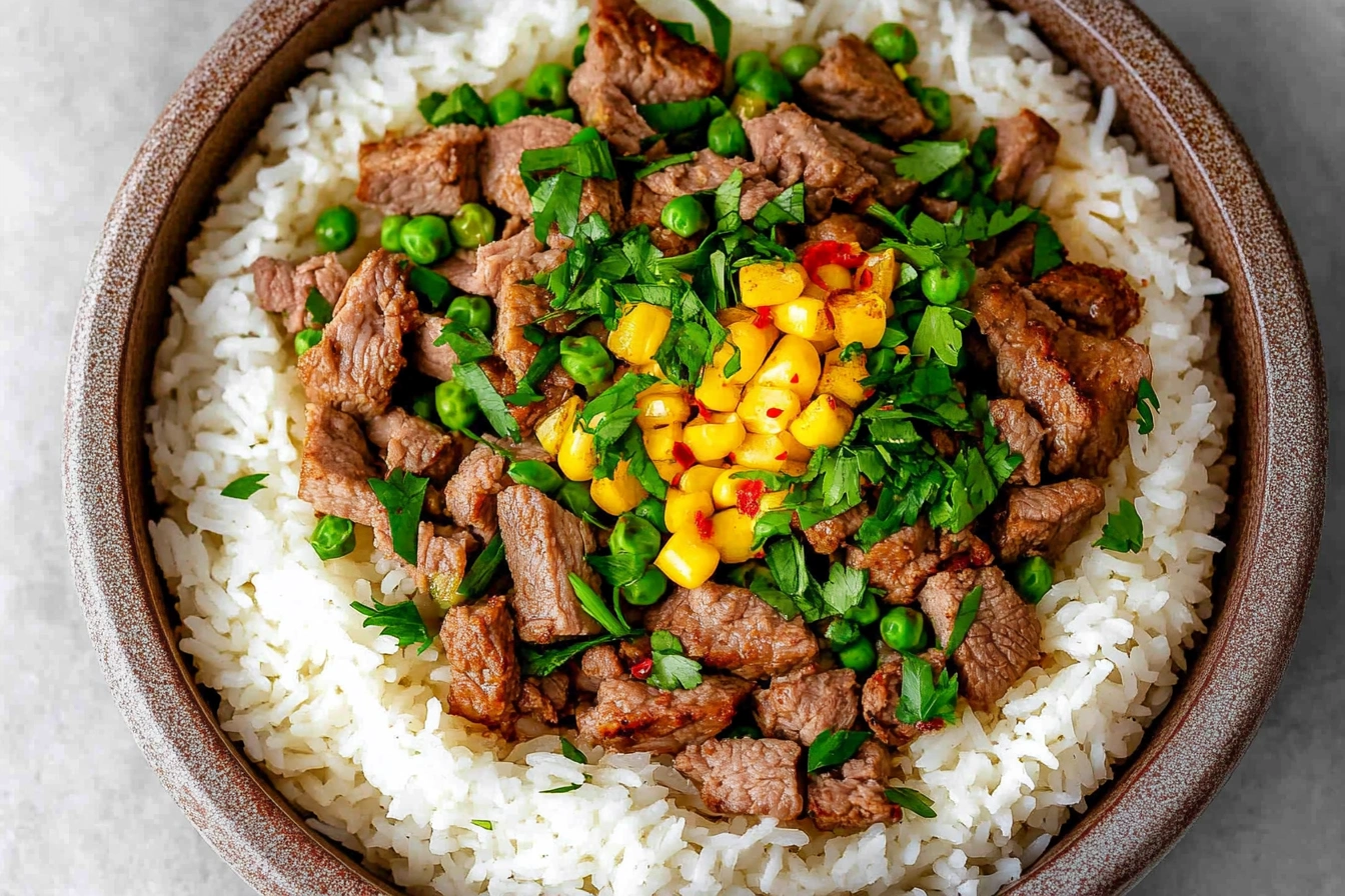 Close-up of Beef Pepper Rice with tender beef, bell peppers, and green onions on a white plate.”