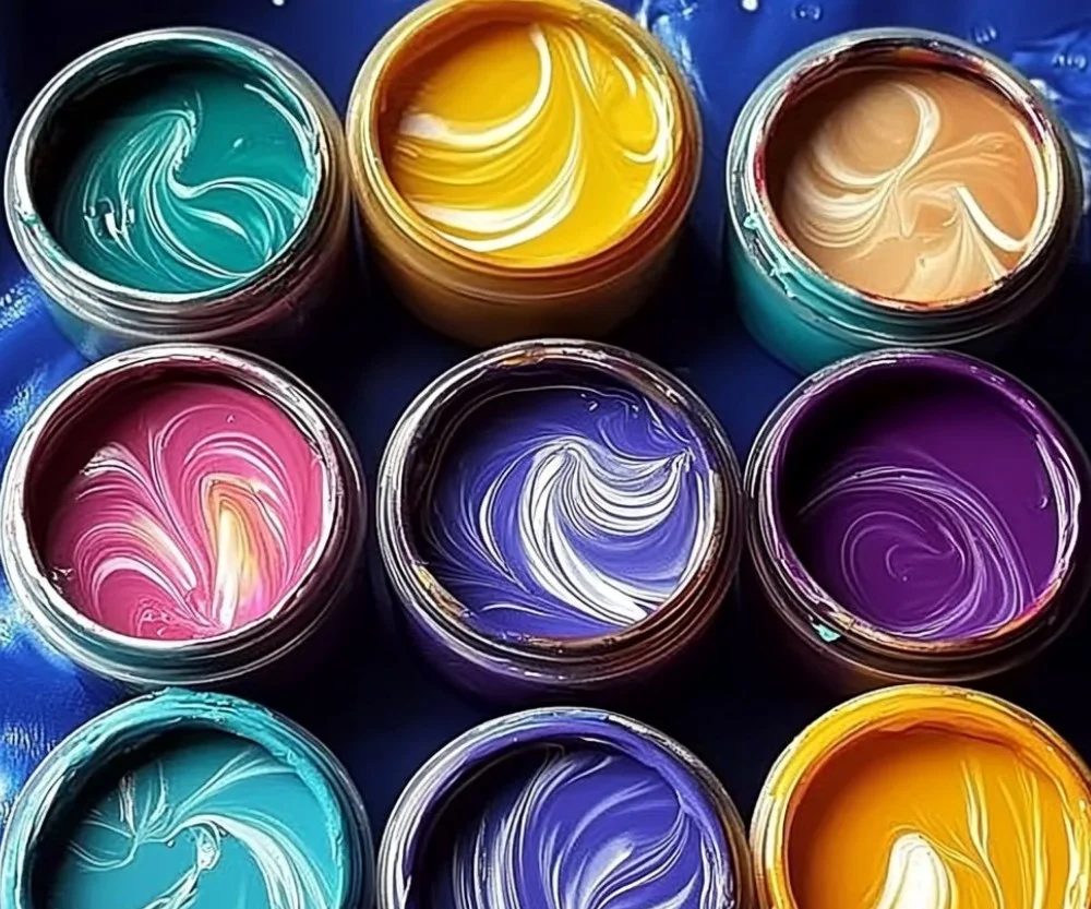 A colorful assortment of homemade edible paint in small containers.