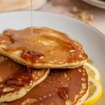 Delicious Lemon poppyseed protein pancakes topped with fresh blueberries and lemon zest.