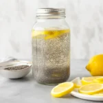 Glass of refreshing chia seed water with lemon slices and chia seeds floating