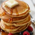 Fluffy pancakes stacked with fresh fruits, representing a healthy breakfast option.