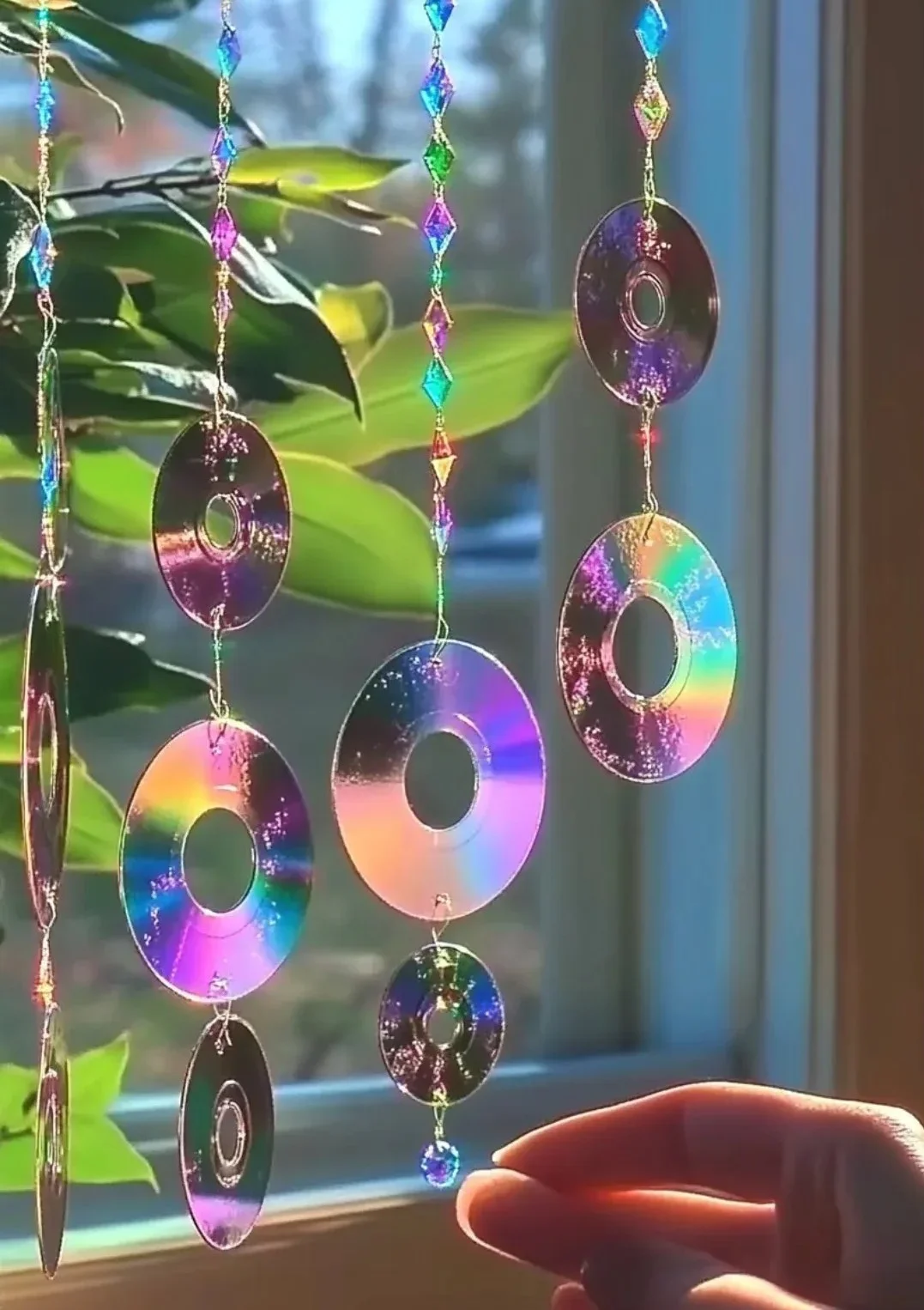 Colorful crafty CD ornaments hanging on a Christmas tree